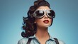 Portrait of beautiful young woman wearing retro aviator goggles on a simple blue background. Vintage fashion, steampunk style. Retro aesthetics, pin-up, 60s vibes. Women's Day