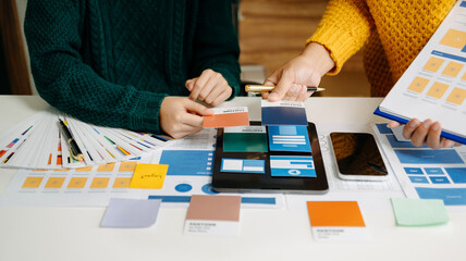  UX developer and ui designer brainstorming about mobile app interface wireframe design with customer breif and color code