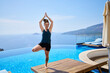 © Westend61 - Woman doing tree pose on deck chair near swimming pool
