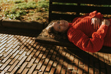 Happy Woman Lying On Bench In Autumn Park