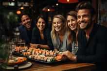 A Beautiful Company Of Young People Is Celebrating In A Restaurant And Eating Sushi
