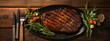 Grilled salmon fish with seasoning and various vegetables on black stone background