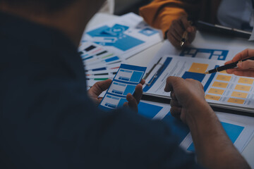 Close up ux developer and ui designer use augmented reality brainstorming about mobile app interface wireframe design on desk at modern office.Creative digital development agency