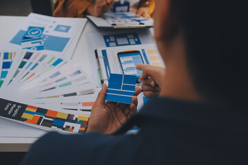 Close up ux developer and ui designer use augmented reality brainstorming about mobile app interface wireframe design on desk at modern office.Creative digital development agency
