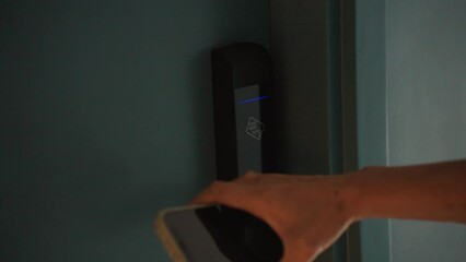 Close-Up hand of woman using smart phone touch to unlock the hotel room door. Digital or keyless to authenticate. Wireless technology.