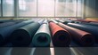 Colored yoga mats are rolled into a roll in an empty gym of a fitness center. Brightly lit large room for sports and relaxation.