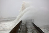 Fototapeta  - Huge Waves crashing a stone pier during a storm at Hartlepool Headland, County Durham, England, UK.