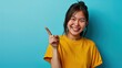 Lucky winner. Cheerful charismatic asian cute urban girl stand yellow t-shirt smiling friendly pointing finger camera choosing, picking person, inviting you team, stand happy blue background