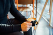 No face handsome young man in black clothes holding hot latte art or cappuccino coffee cup in modern cafe shop. Warm and cozy fall or winter moments. Take a break to relax. Soft selective focus