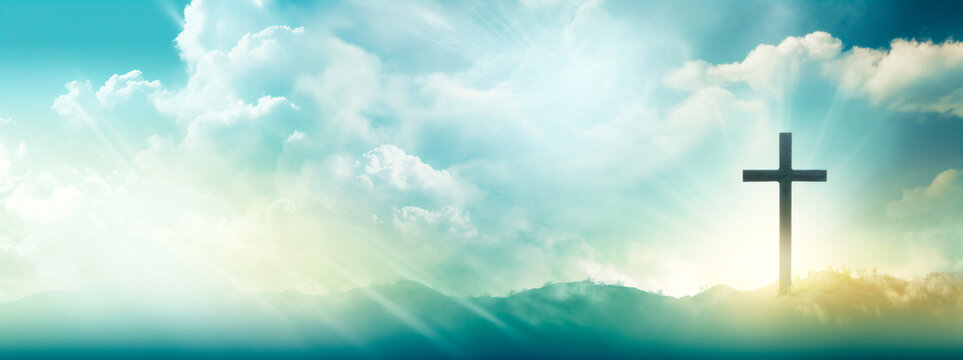 cross in the mountains, against the light, over the sky