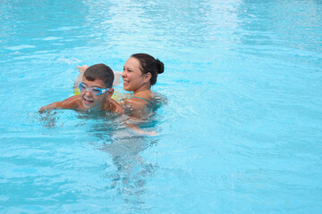 Mother and son's pool time; cherished vacation joy. Aligns with the movement towards quality family time in tourism.