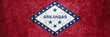 Banner of the grunge Arkansas state flag. Dirty Arkansas state flag on a metal surface.