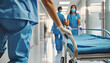 Hospital staff carry empty stretcher in the corridor