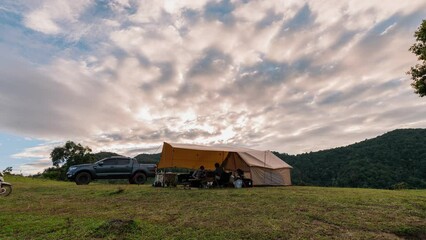 Wall Mural - Tourists camping a tent on hill in the evening at countryside