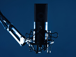 Wall Mural - Condenser microphone on tripod. Professional mic for sound recording. Microphone on dark background. Equipment for radio presenters. Microphone for studio recording. Condenser mike close up