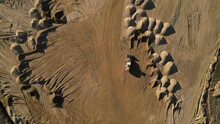 Arial View Of Open Pit Sand Mine. A Front Loader Loads Sand From Piles. Heavy Mining Machinery Working In A Quarry. Lots Of Wheel Tracks And Piles Of Sand Like Desert Dunes, Dry, Sandy,sell
