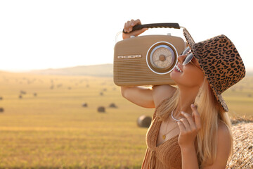 Poster - Happy hippie woman with radio receiver in field, space for text