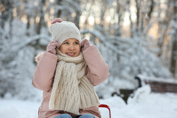 Sticker - Cute little girl in snowy park on winter day