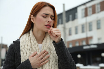 Canvas Print - Beautiful young woman coughing outdoors, space for text. Cold symptoms