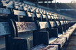 Empty football bleachers, a perspective shot focusing on vacant seating in a football stadium, emphasizing the solitude and anticipation before an event.