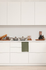 Canvas Print - White kitchen counters with cutting boards, electric stove, cooking pots and utensils