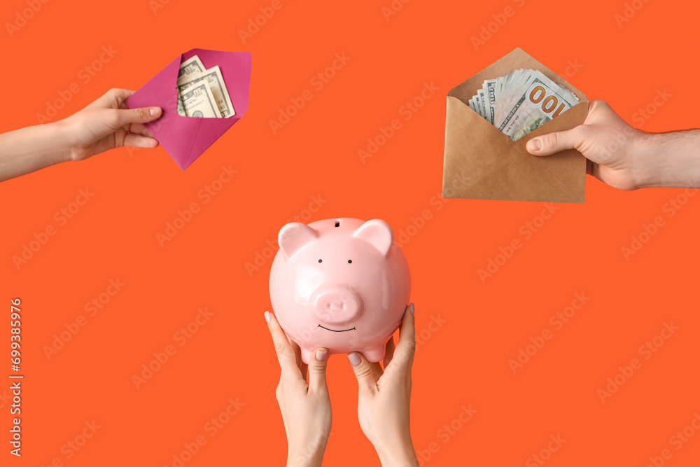 Hands with piggy bank, envelopes and money on orange background