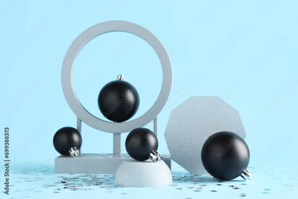 Decorative stands with different Christmas balls and snow on blue background
