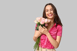 Fototapeta Tulipany - Pretty young woman with bouquet of beautiful roses on grey background. Valentine's Day celebration