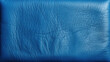 Close-up of blue leather material highlighting its textured surface and detail, suitable for backgrounds or design elements.