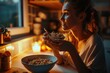 Woman sitting at a table, enjoying a bowl of cereal. Perfect for breakfast or healthy lifestyle concepts