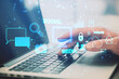 Close up of male hand using laptop on desk with creative social media interface with emails, speech bubbles, mobile internet, cloud computing and other icons on blurry background. Double exposure.