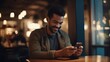© Zainab - A handsome young man texting and using on his mobile smartphone and smiling in a cafe bar. blurry background. late in the night evening