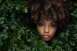 A close-up of a woman's face surrounded by leaves, capturing a beautiful portrait photo with a natural complexion and radiant skin