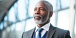 Confident 60 years old african american business man in business suit posing , bright background, beautiful soft daylight copy space 