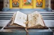 weathered bible with torn pages open on a chapels lectern