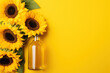 A bottle of sunflower oil and sunflower on yellow background.