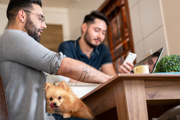 detail of dog licking face in lap at table