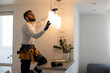 © Angelov - Electrician installs lamp lighting and spot loft style on ceiling.