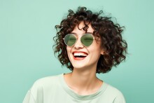 Happy Young Laughing Beautiful Asian Woman Wearing Sunglasses On Green Background