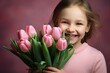 © Лена Шевчук - A girl smiling and holding a bouquet of pink tulips. The concept of March 8. Women's Day