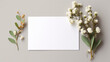 Feuille de papier blanc entourée de fleurs, plantes, branchages. Composition florale. Mock-up pour carte, création et conception graphique. Arrière-plan clair, épuré, naturel. 