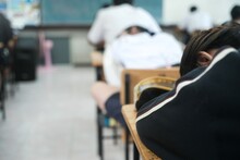 A Female Student Who Is Tired From Taking A Difficult Exam Is Discouraged And Falls Asleep During The Exam Due To Stress. The Student Collapses On The Table Inside The Exam Room