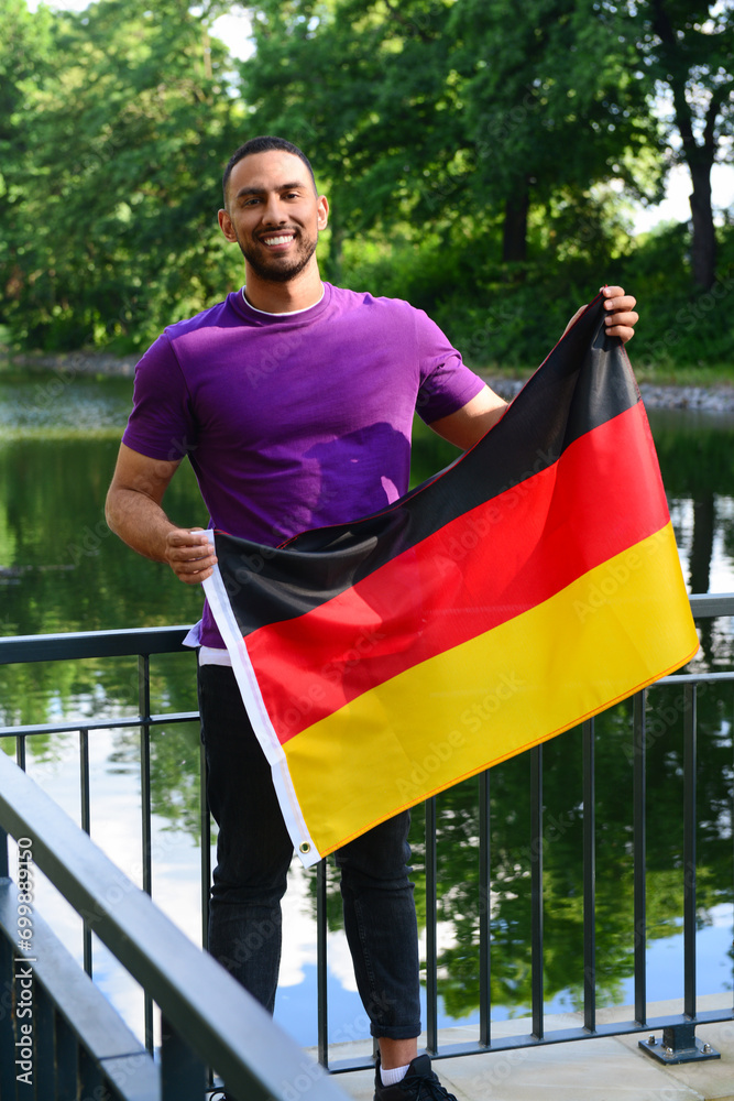 Young man with flag of Germany in park