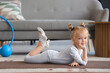 © Pixel-Shot - Cute little girl lying on fitness mat at home