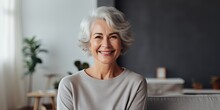 Happy Beautiful Relaxed Mature Older Adult Grey-haired Woman Drinking Coffee Relaxing On Sofa At Home. Smiling Stylish Middle Aged 60s Lady Enjoying Resting Sitting On Couch
