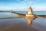 Fototapeta Góry - Sunset at Windmills in the salt evoporation pond in Marsala, Sicily island, Italy
Trapani salt flats and old windmill in Sicily.
View in beautifull sunny day.