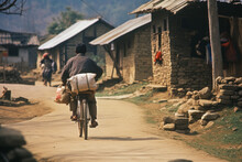 A Man Rides A Bicycle With Things In An Asian Village