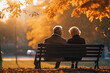 an elderly couple sits on a bench in an autumn park