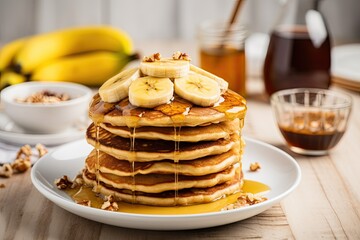 Sticker - Healthy breakfast of oatmeal banana pancakes topped with fresh bananas walnuts honey and a cup of tea on a white wooden background Copy space