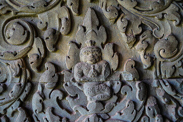 Ancient asian stone wall with human and flower ornaments in Cambodia Angkor Wat Siem Reap for pattern background horizontal 2